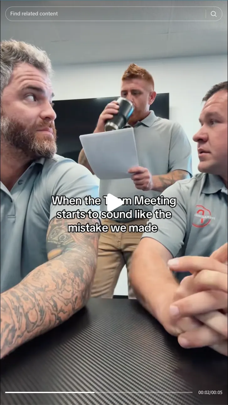 Roofing by Prodigy - Three men in gray polo shirts in a meeting room; one standing drinking from a tumbler and holding papers, two sitting and looking concerned, with caption about a team meeting mistake.